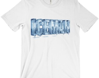 Puede incluir: Camiseta blanca con la palabra "ICEMAN" en una fuente azul y helada. Las letras parecen estar hechas de hielo, con detalles goteando. La camiseta es de estilo cuello redondo clásico.