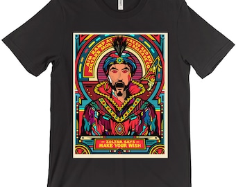 Puede incluir: Una camiseta gráfica colorida con una ilustración de dibujos animados de un hombre con turbante y barba. El texto en la camiseta dice "Aim Ramp at Zoltar's Mouth" y "Press Red Button to Release Coin". La parte inferior de la camiseta dice "Zoltar Says - Make Your Wish".