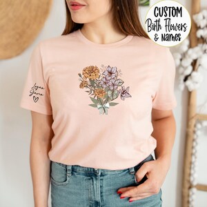 a woman wearing a pink t - shirt with flowers on it