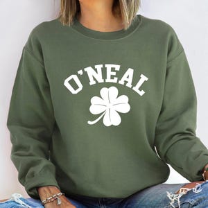 a woman wearing a green sweatshirt with a shamrock on it