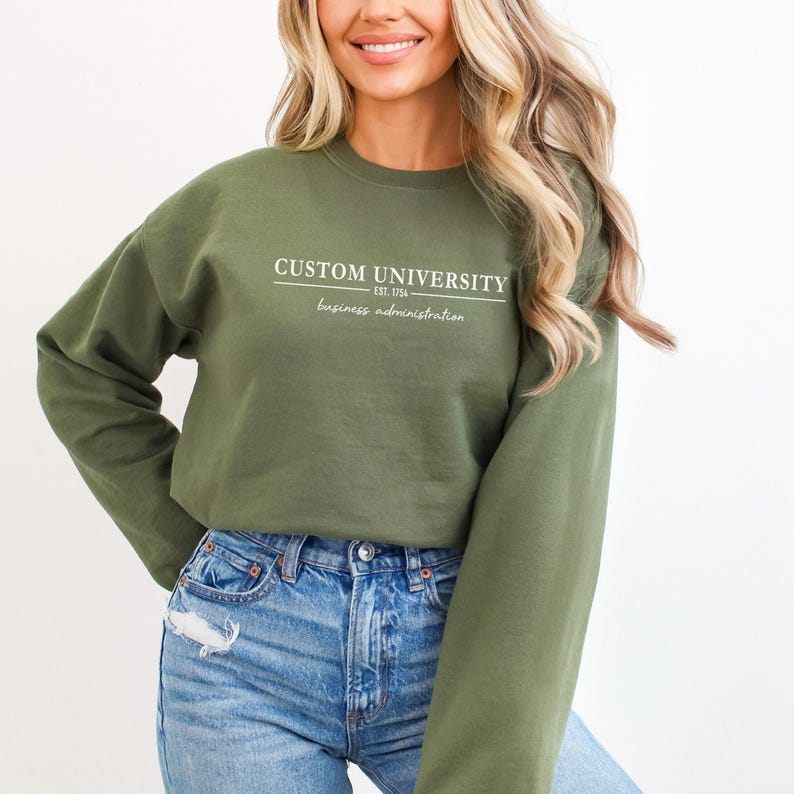 a woman wearing a green sweatshirt that says custom university