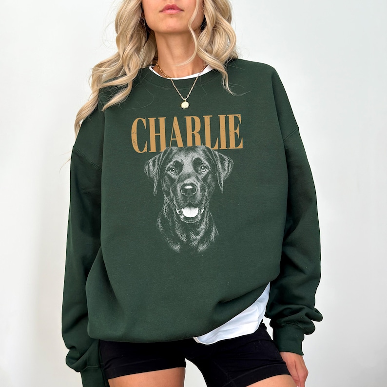 A woman wearing a green sweatshirt with a black dog printed on it.