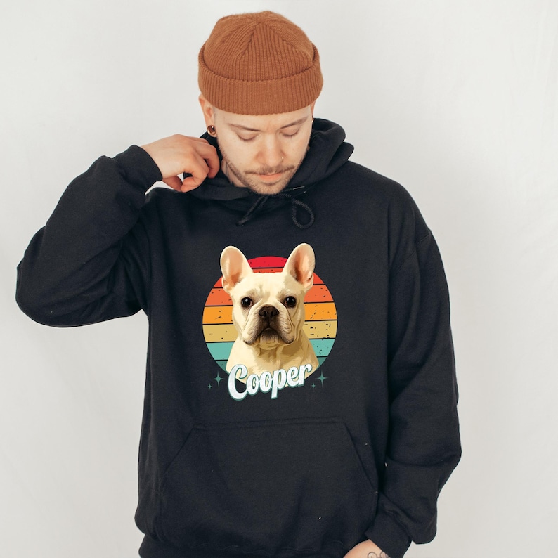 A man wearing a black hoodie with a graphic of a dog and the name "Cooper" printed on it.