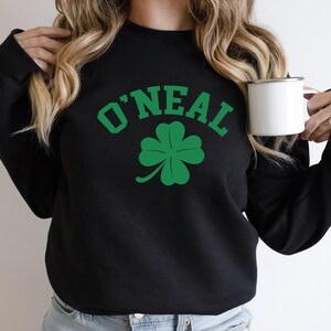 a woman holding a cup of coffee and wearing a sweatshirt
