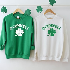 two green and white sweatshirts hanging on a wall