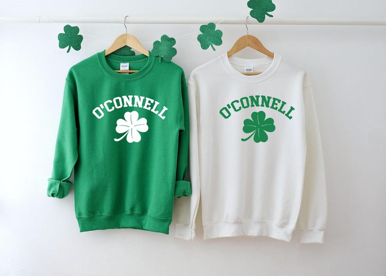 two green and white sweatshirts hanging on a wall
