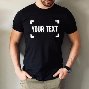 A man wearing a black t-shirt with the text "YOUR TEXT" printed on it.