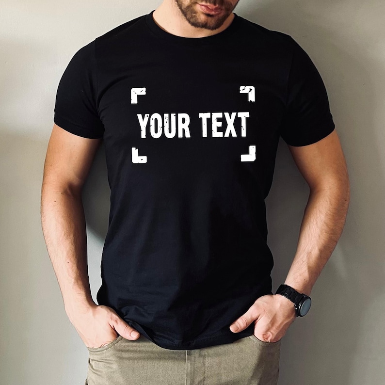 A man wearing a black t-shirt with the text "YOUR TEXT" printed on it.
