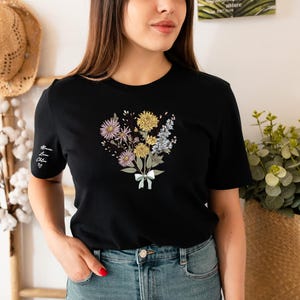 a woman standing in front of a wall with flowers on it