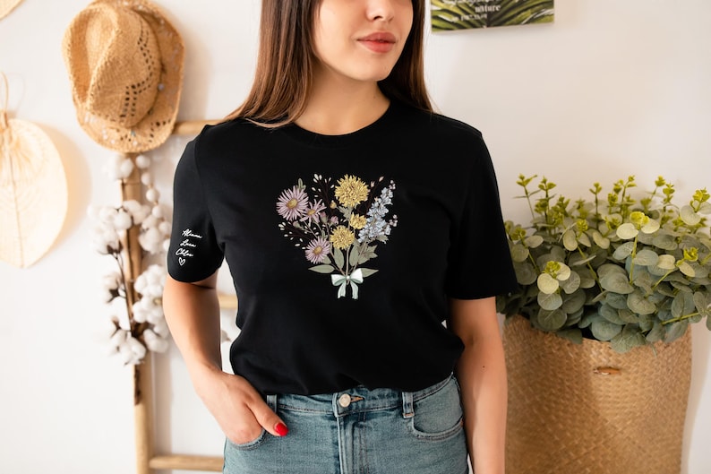 a woman standing in front of a wall with flowers on it
