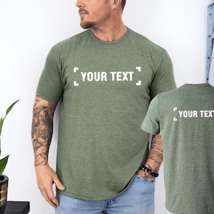 a man standing next to a plant wearing a t - shirt that says your text