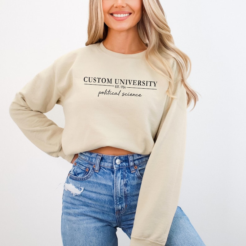 a woman wearing a cropped sweatshirt with the words custom university printed on it