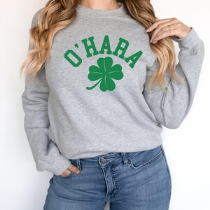 a woman wearing a sweatshirt with a shamrock on it