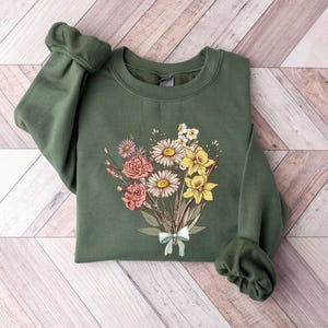a green sweatshirt with a bouquet of flowers on it