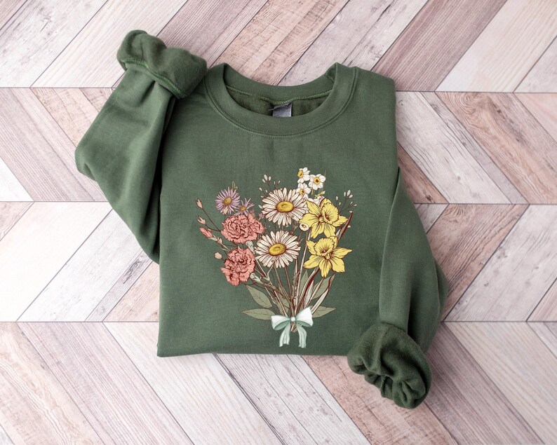 a green sweatshirt with a bouquet of flowers on it