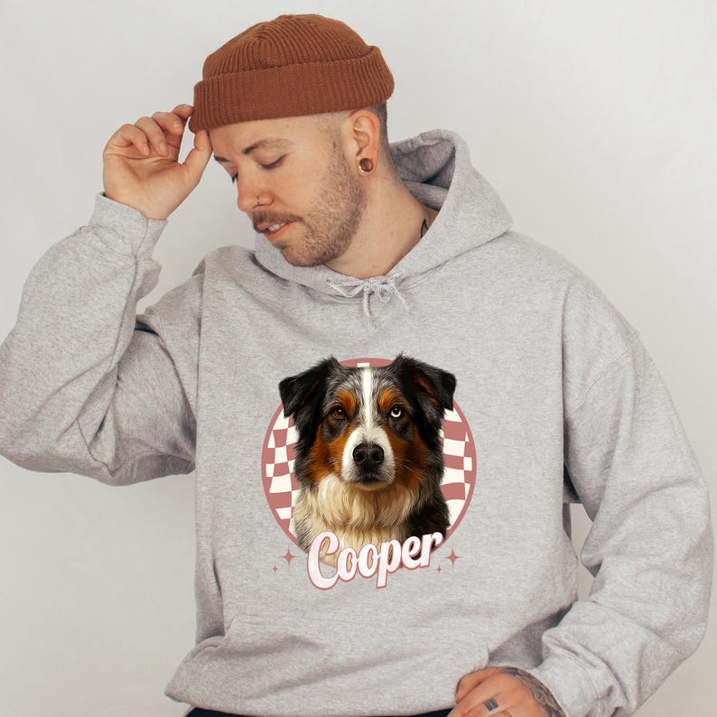 A man wearing a grey hoodie with a graphic of a dog and the word "Cooper" printed on it.