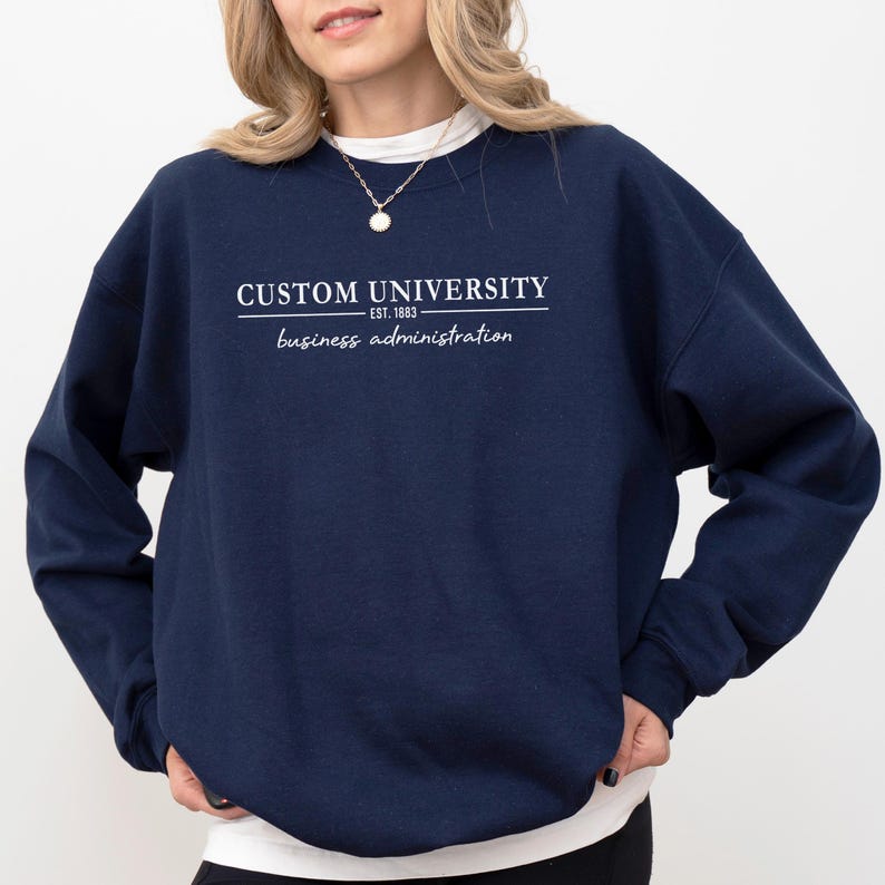a woman wearing a sweatshirt that says custom university