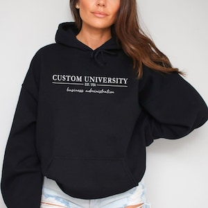 a woman wearing a black hoodie that says custom university