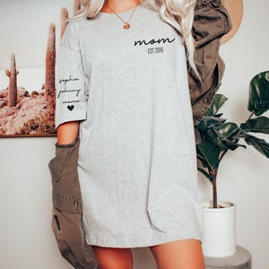a woman with blonde hair wearing a grey shirt dress