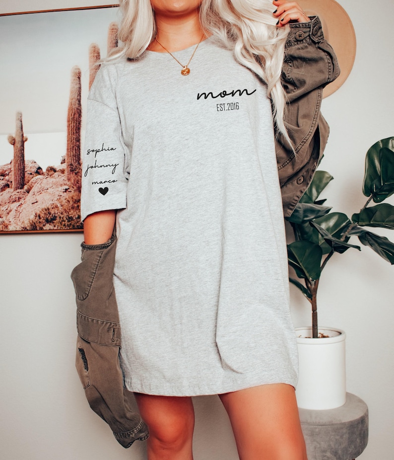 a woman with blonde hair wearing a grey shirt dress