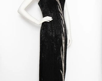 May include: A black sequined evening gown with a silver beaded design. The gown has a V-neckline and spaghetti straps.