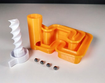 May include: Orange 3D printed marble run with a white spiral ramp and four silver metal marbles.