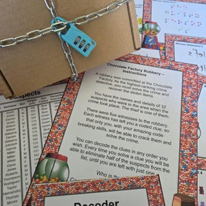 Pu&ograve; includere: Una scatola di cartone marrone fissata con una catena di metallo argentato e un lucchetto a combinazione azzurro a tre cifre. Accanto alla scatola ci sono fogli di istruzioni di gioco intitolati Chocolate Factory Robbery con bordi colorati.