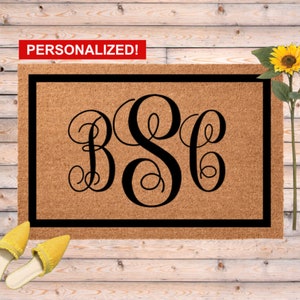 May include: A rectangular coir doormat with a black border and a large, black monogram of the letters B, S, and C. The word "PERSONALIZED!" is in a red banner at the top. Yellow shoes and a sunflower are in the background.
