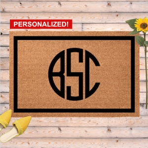 May include: A rectangular doormat with a black border and a large black monogram. The monogram features the letters "BSC" inside a circle. The word "PERSONALIZED!" is in a red banner at the top.