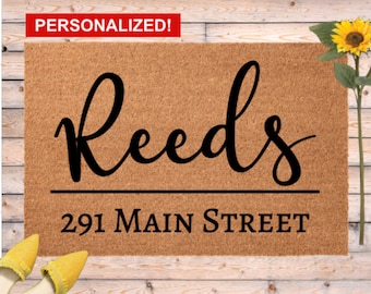 Könnte beinhalten: Rechteckige Fußmatte aus Naturkokosfaser. Der Name "Reeds" ist in einer stilvollen Schriftart geschrieben, darunter die Adresse "291 Main Street". Ein rotes Banner oben zeigt "PERSONALISIERT!". Eine Sonnenblume und gelbe Schuhe sind im Hintergrund.