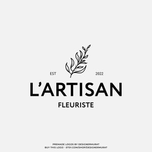 May include: Black and white logo design for a florist business called "L'Artisan Fleuriste" established in 2022. The logo features a stylized floral branch.