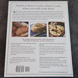 May include: A cookbook titled "Thanks to Betty Crocker, dinner's ready when you walk in the door!" features recipes for slow cooker and quick-prep oven dishes. The book includes over 350 recipes, with many requiring only 30 minutes or less of prep time.