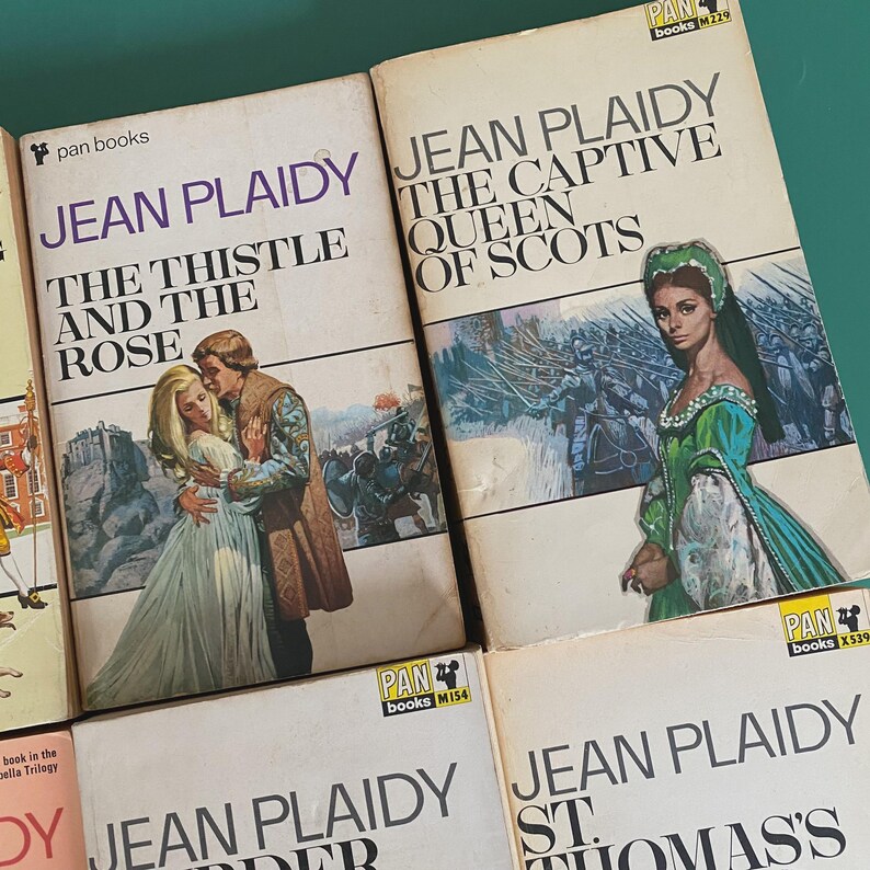 May include: A selection of vintage Jean Plaidy paperback books. The covers display illustrations of historical scenes and figures, including titles such as "The Thistle and the Rose" and "The Captive Queen of Scots". Published by Pan Books.
