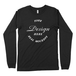 May include: Black long-sleeve t-shirt with a white circle design that says "YOUR DESIGN HERE REAL MOCKUPS".