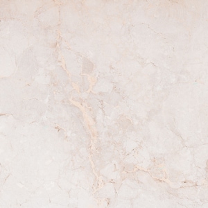 Op de afbeelding: Een close-up van een lichtbeige marmeren oppervlak met een subtiel aderingspatroon.