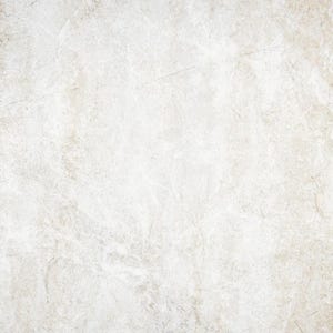 Op de afbeelding: Een close-up van een wit, getextureerd oppervlak met een subtiele beige tint. Het oppervlak heeft een ruwe, ongelijke textuur, die doet denken aan een verweerde muur of beton.