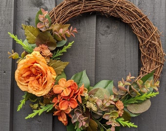 Autumn wreath for your front door with a cabbage rose, eucalyptus, autumn colours