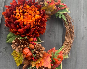 Deep  orange  autumn wreath for your front door, with berries,acorns and pumpkins