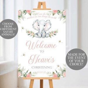 May include: A white welcome sign on a wooden easel, featuring a watercolor illustration of a baby elephant, flowers, and bees. Text includes "Welcome to Neave's Christening" and "Even the smallest one can change the world."