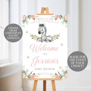 May include: A baby shower welcome sign on a wooden easel. The sign features a watercolor zebra illustration, floral accents, and the text "Welcome to Jessica's Baby Shower." Additional text includes "Choose from 4 Different Safari Animals!" and "Made for the Event of Your Choice!"