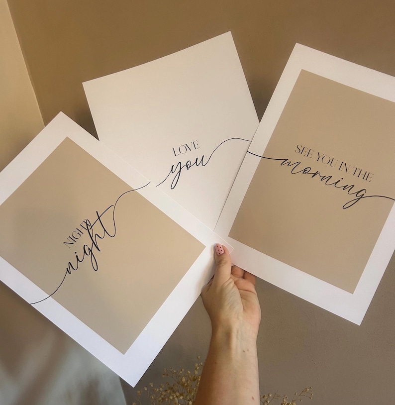 May include: Three rectangular wall art prints featuring a beige center panel with a white border. The prints display black text in a mix of serif and script fonts: "night night", "LOVE you", and "SEE YOU IN THE morning" written in a flowing style.