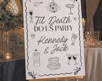 May include: A white rectangular wedding sign on a gold easel featuring black line art illustrations of a disco ball, champagne glasses, a cake, and a wine bottle. The text reads: Til Death DO US PARTY, Kennedy & Jack, with decorative bows.