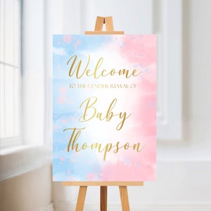 May include: Welcome to the gender reveal of Baby Thompson sign with a blue and pink watercolor background. The text is in gold.