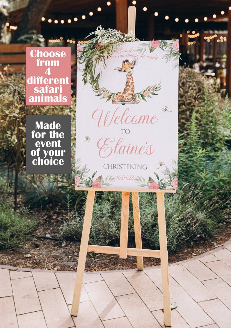 May include: A wooden easel displays a welcome sign for Elaine's christening. The sign features a giraffe illustration, floral accents, and the text "Welcome to Elaine's Christening 16.04.23". Additional text reads "Choose from 4 different safari animals".