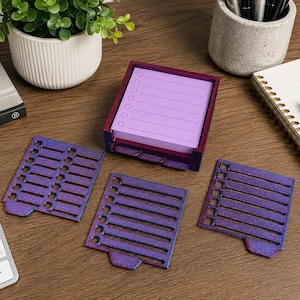 May include: A square purple holder containing a stack of light purple sticky notes with printed checklist lines and circles. Three additional purple, textured, square checklist templates with cut-out lines and circles are arranged in front.