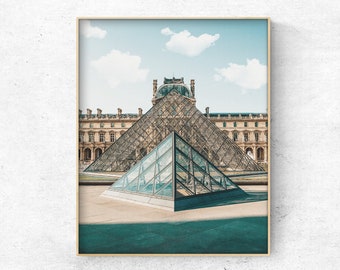 May include: A glass pyramid structure in front of the Louvre Museum in Paris, France. The pyramid is made of glass panels and reflects the blue sky and white clouds. The museum building is in the background.