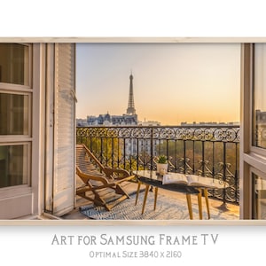May include: A balcony with a view of the Eiffel Tower in Paris, France. The balcony has a wooden table and two chairs, and a book is lying on the table. The balcony is surrounded by a wrought iron railing.