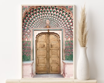 May include: A photograph of a large, ornate, golden door with intricate carvings. The door is set within a colorful archway with a peacock feather design. The archway is decorated with pink, green, and blue tiles.