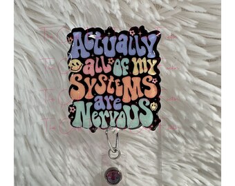 Op de afbeelding: Een zwart-witte badgehouder met een kleurrijk, glitterend retro-ontwerp met de tekst "Actually all of my systems are nervous".