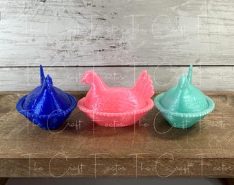 May include: Three colorful hen-shaped containers. The containers are in blue, pink, and teal. The pink hen is in the center, with a detailed body and a basket-like base. The other two containers have a similar basket base and a pointed top.